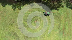 Australian man riding ride on lawn mower cutting green