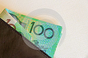 Australian one hundred dollar notes in a black leather wallet.