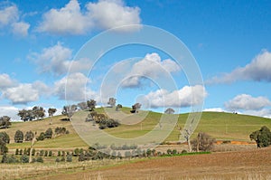 Australian rural landscape with hills and farmland against blue sky. Background texture of beautiful countryside scenery photo