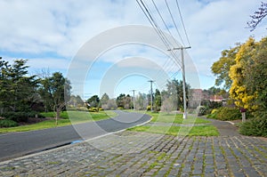 An Australian suburban quiet neighbourhood street with electricity poles along the road. Werribee, VIC Australia