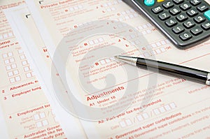 Australian tax forms with pen and calculator. Financial document. Tax time.