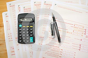 Australian tax forms with pen and calculator. Financial document.