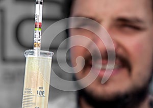 Australian winemaker measures grape sugar level using a Baume hydrometer at a small winery near Hahndorf in the Adelaide Hills of