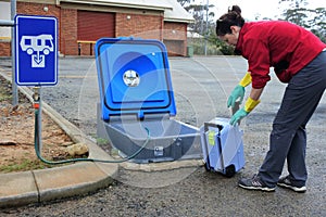 Australian woman emptying a caravan tank toilet cassette in a dumping point