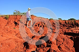 Australian woman hiking on red cliff in Cape Leveque Western Australia