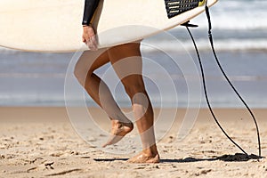 Australian Woman surfer walking along the Beach whit her Surfboard. Water Deport Concept