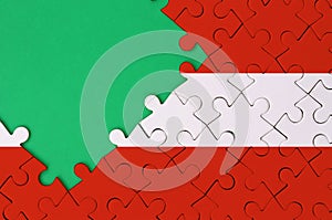 Austria flag is depicted on a completed jigsaw puzzle with free green copy space on the left side
