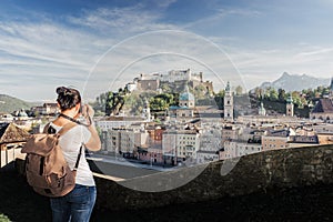 Austria. Salzburg. A young tourist girl takes pictures