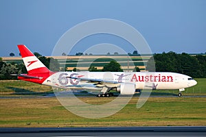Austrian Airlines plane doing taxi on taxiway, 60 years livery