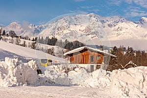 Austrian bus and wooden house. Mountains at the background. Ski region Schladming-Dachstein, Liezen, Styria, Austria