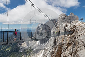 Austrian Dachstein Mountains with hikers passing a skywalk rope