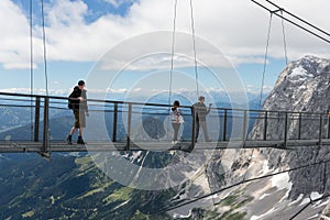 Austrian Dachstein Mountains with hikers passing a skywalk rope