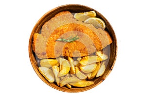 Austrian fried weiner schnitzel with potato wedges in a wooden plate. Isolated on white background.