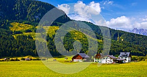 Austrian village among meadows fields and Alpine