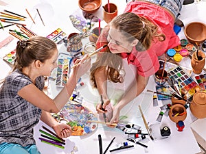 Authentic artist children girl paints on floor. Top view.