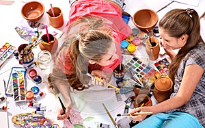 Authentic artist children girl paints on floor. Top view.