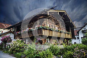 An authentic Bavarian Waldlerhaus with a lot of flowers in a garden