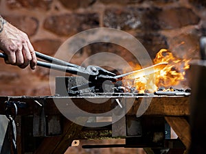 Authentic blacksmith forges metal on the anvil. Medieval traditions