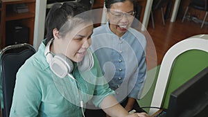 Authentic blind person woman with headphone using computer with braille display assistive device discussing with senior colleague