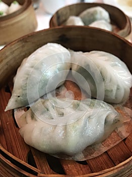 Authentic Chinese dumplings or Dim Sum on a wooden basket, Asian delight