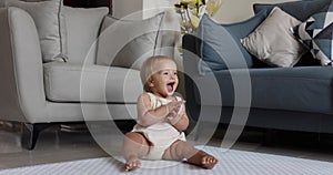 Authentic close up Cute Caucasian Baby Girl 1 year old Playing on floor in living room at home. Slow Motion.