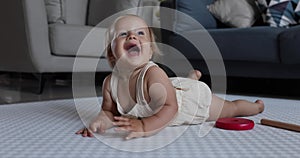 Authentic close up Cute Caucasian Baby Girl 1 year old Playing on floor in living room at home. Slow Motion.