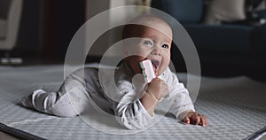 Authentic close up Cute Caucasian Baby Girl 6-7 months old Playing with plastic toy on floor in living room at home