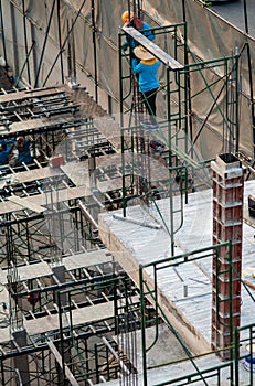 Authentic construction worker busy on the positioning of formwork frames in construction site