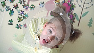 authentic cute happy child preschool girl puts jigsaw puzzle top view close up. little kid play alone educational games