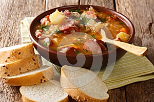 Authentic Czech cabbage soup with sausages and vegetables close-up in a bowl. horizontal