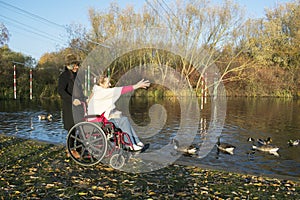 Authentic Disabled Female in Wheelchair With Asian Caregiver, Carer, Real, Healthcare.