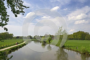 Authentic Dutch landscape with river Kromme Rijn, walkway, clouds and trees