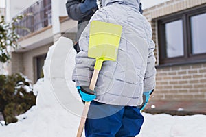 Authentic family winter fun. Family building a snowman in their frontyard. Candid real people lifestyle image. photo