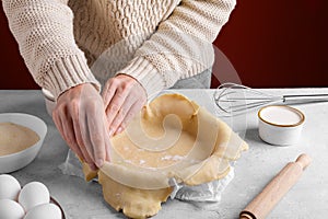 Authentic female hands are putting homemade crust pie dough into a baking dish, Pie crust recipe, hobby home bakery