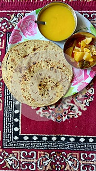 Authentic Gujrati lunch dish with mango juice and roti with potato vegetables, India.