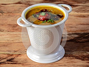 Authentic Indian popular food Dal Tadka Curry or Traditional Indian soup lentils on rustic wooden background. selective focus