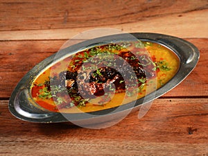 Authentic Indian popular food Dal Tadka Curry or Traditional Indian soup lentils on rustic wooden background. selective focus