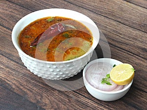 Authentic Indian popular food Dal Tadka Curry or Traditional Indian soup lentils on rustic wooden background. selective focus