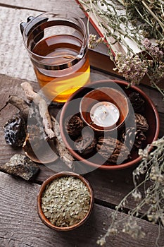 Authentic interior details, glass of herbal rea, dry herbal plants, homeopathic treatment on rustic wooden background, alternative photo