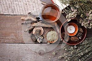 Authentic interior details, glass of herbal rea, homeopathic treatment on rustic wooden background top view, alternative medicine