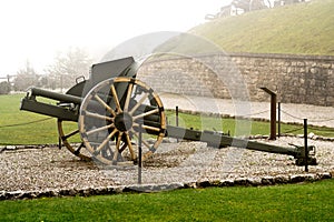 Authentic Italian cannon on a white foggy background and a pebble pavement located in the city of Valli del Pasubio, Italy from