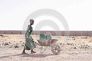 Authentic Native African Girl Carrying Fresh Water for lack of water symbol photo