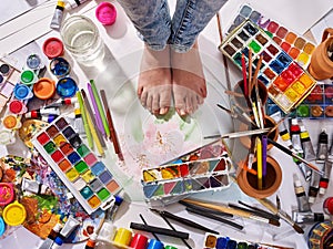 Authentic paint brushes still life on floor in art class school.