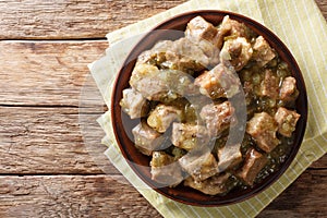 This authentic pork chile verde recipe. Tender pieces of pork slow cooked with a green chile sauce (salsa verde) closeup. horizon photo