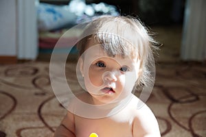 Authentic portrait of baby girl. Little child face closeup in natural light at home. Caucasian kid