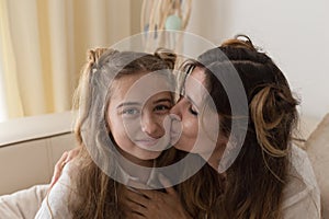 Authentic portrait of mother kissing her daughter