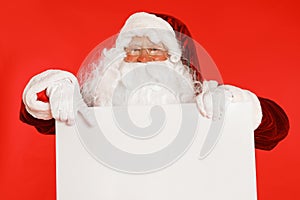 Authentic Santa Claus with blank  on red background. Space for design