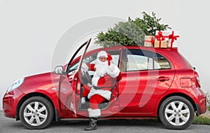 Authentic Santa Claus in car with gift boxes