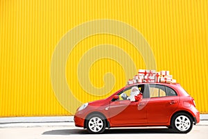 Authentic Santa Claus driving red car with gift boxes photo