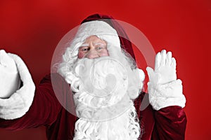 Authentic Santa Claus taking selfie on red